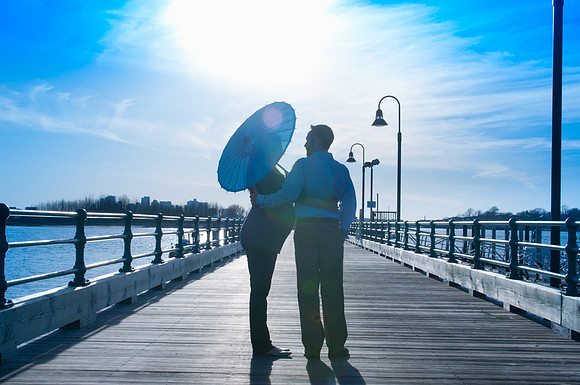 Couple expecting a baby standing on a pier at sunset in Boston